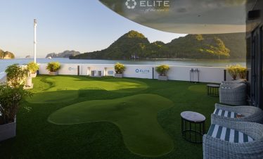 Stunning view of Halong Bay from cruise balcony with lush green islands and calm waters.