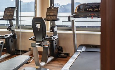 Modern gym equipment with scenic view of Halong Bay for active travelers.