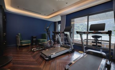 Relaxing gym with scenic bay view on Halong Bay cruise ship.