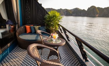 Relaxing cruise balcony view of Halong Bay with scenic limestone islands and calm waters.