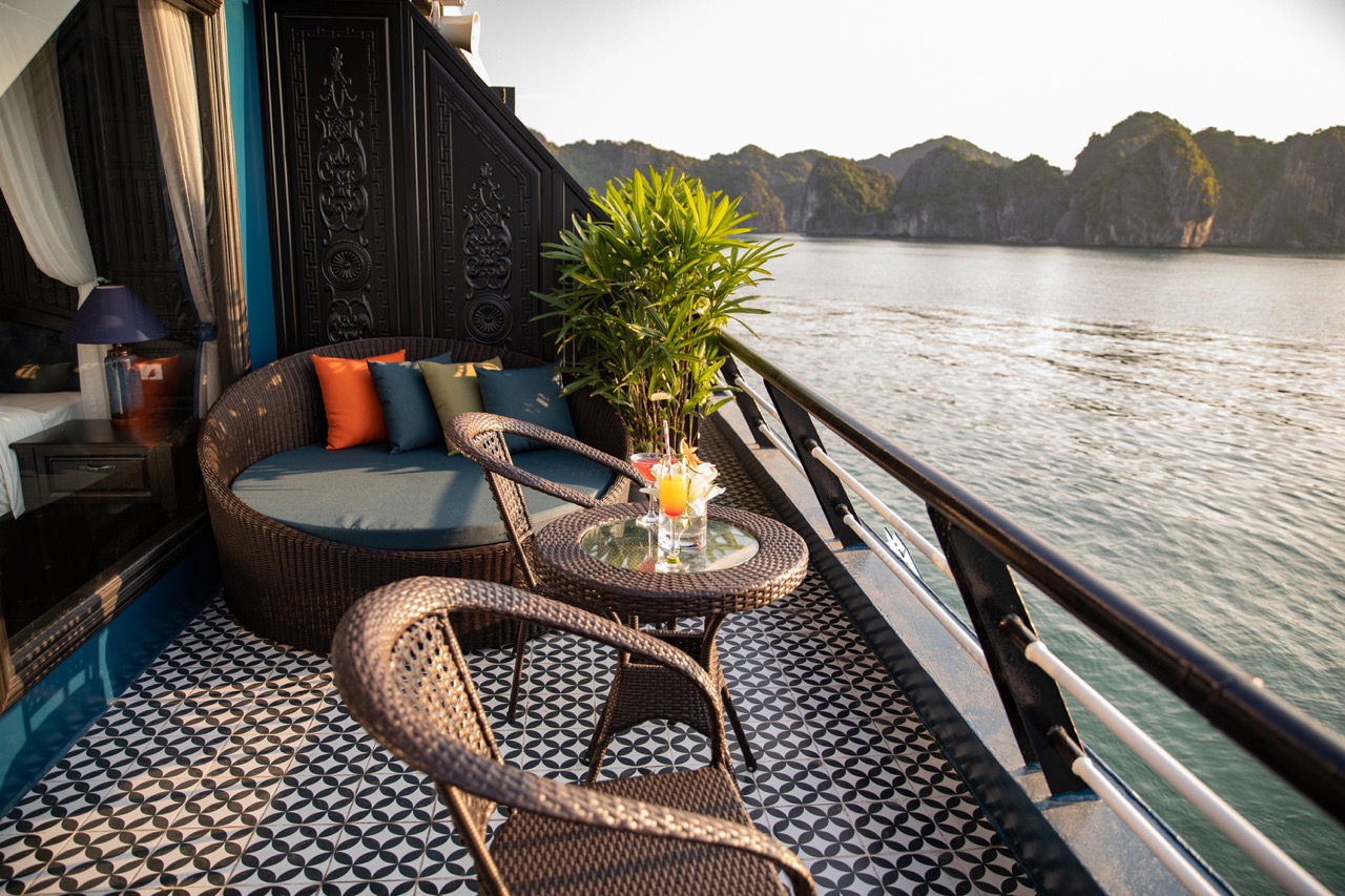 Relaxing cruise balcony view of Halong Bay with scenic limestone islands and calm waters.