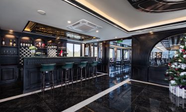 Luxurious cruise lounge with panoramic windows and elegant decor in Halong Bay.