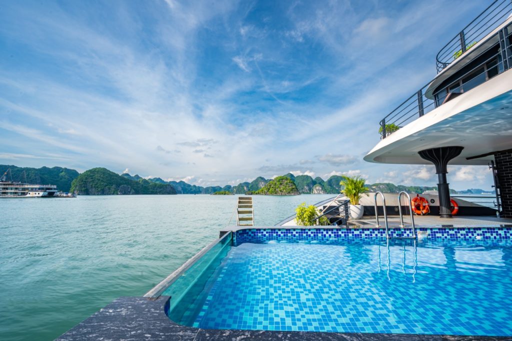 Luxury Halong Bay cruise balcony with stunning sea views and clear blue sky.