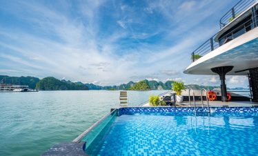 Luxury Halong Bay cruise balcony with stunning sea views and clear blue sky.