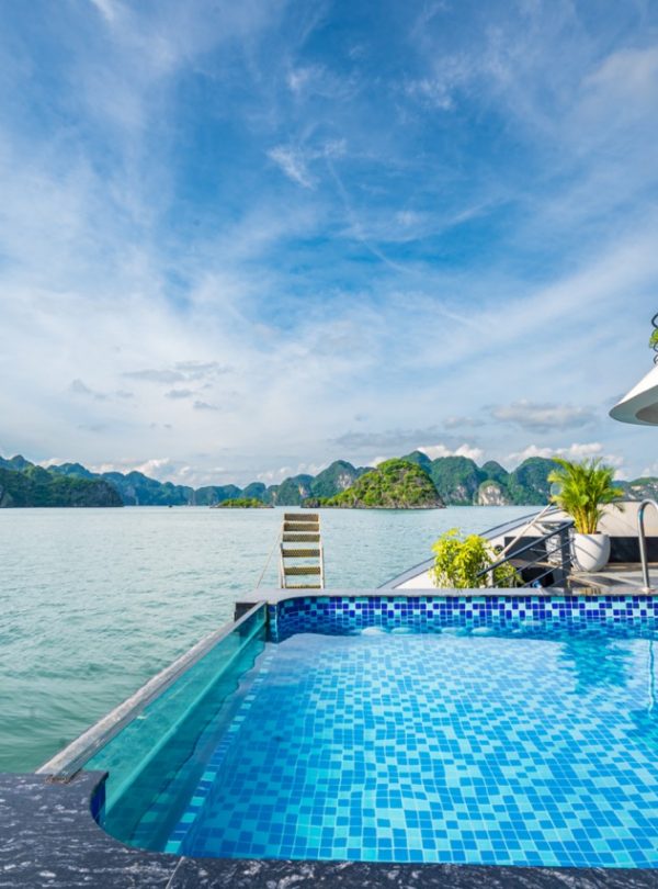 Luxury Halong Bay cruise balcony with stunning sea views and clear blue sky.