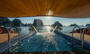 Stunning view from a luxury cruise balcony in Halong Bay with limestone karsts and calm waters.