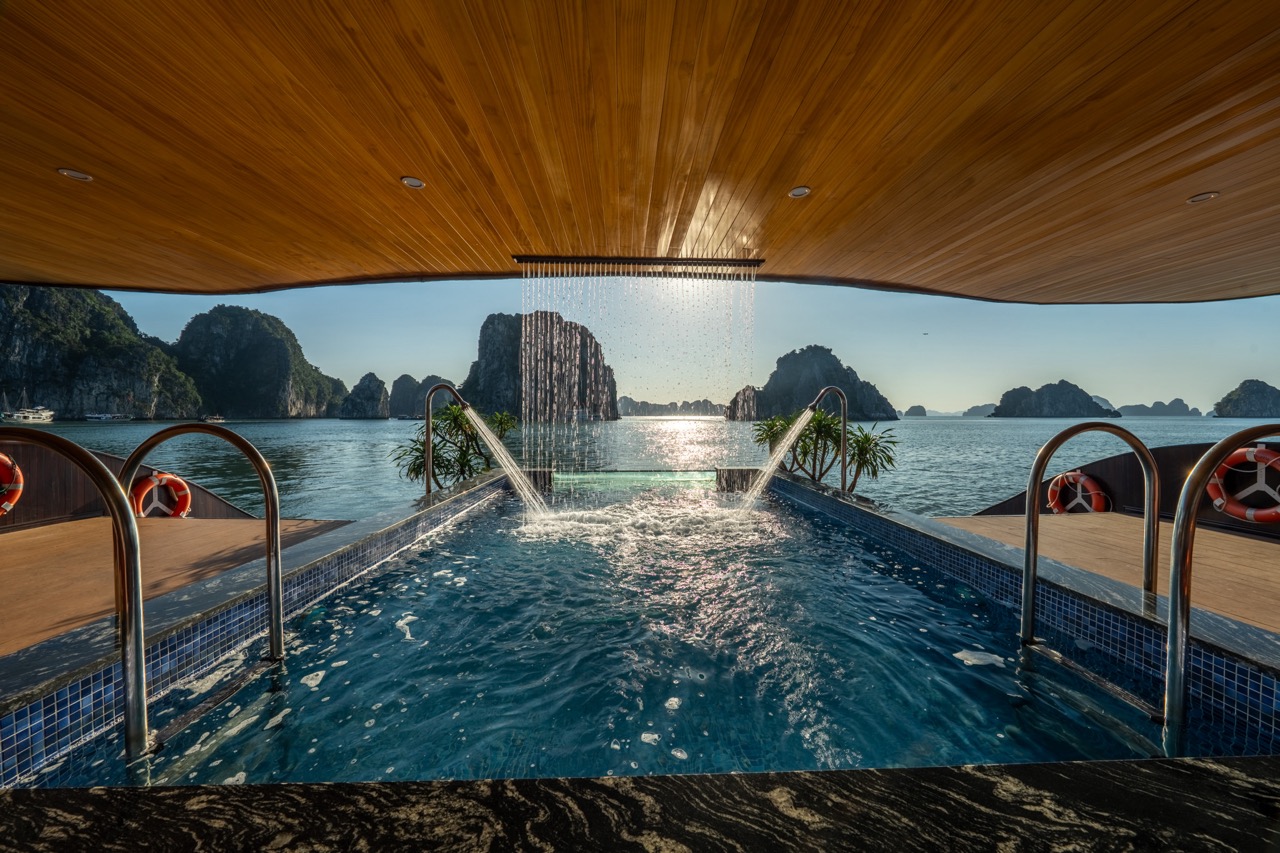 Stunning view from a luxury cruise balcony in Halong Bay with limestone karsts and calm waters.