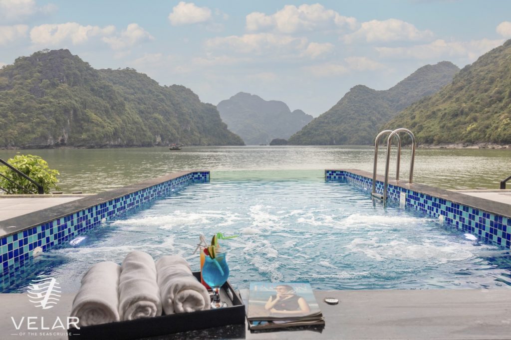 Stunning view of Halong Bay from the cruise balcony with relaxing poolside scene.