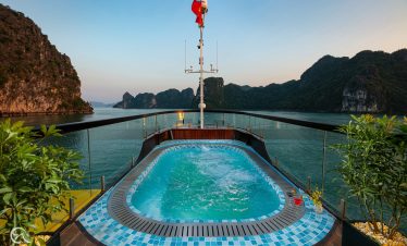 Stunning view from a cruise balcony in Halong Bay, showcasing limestone karsts and tranquil waters,.