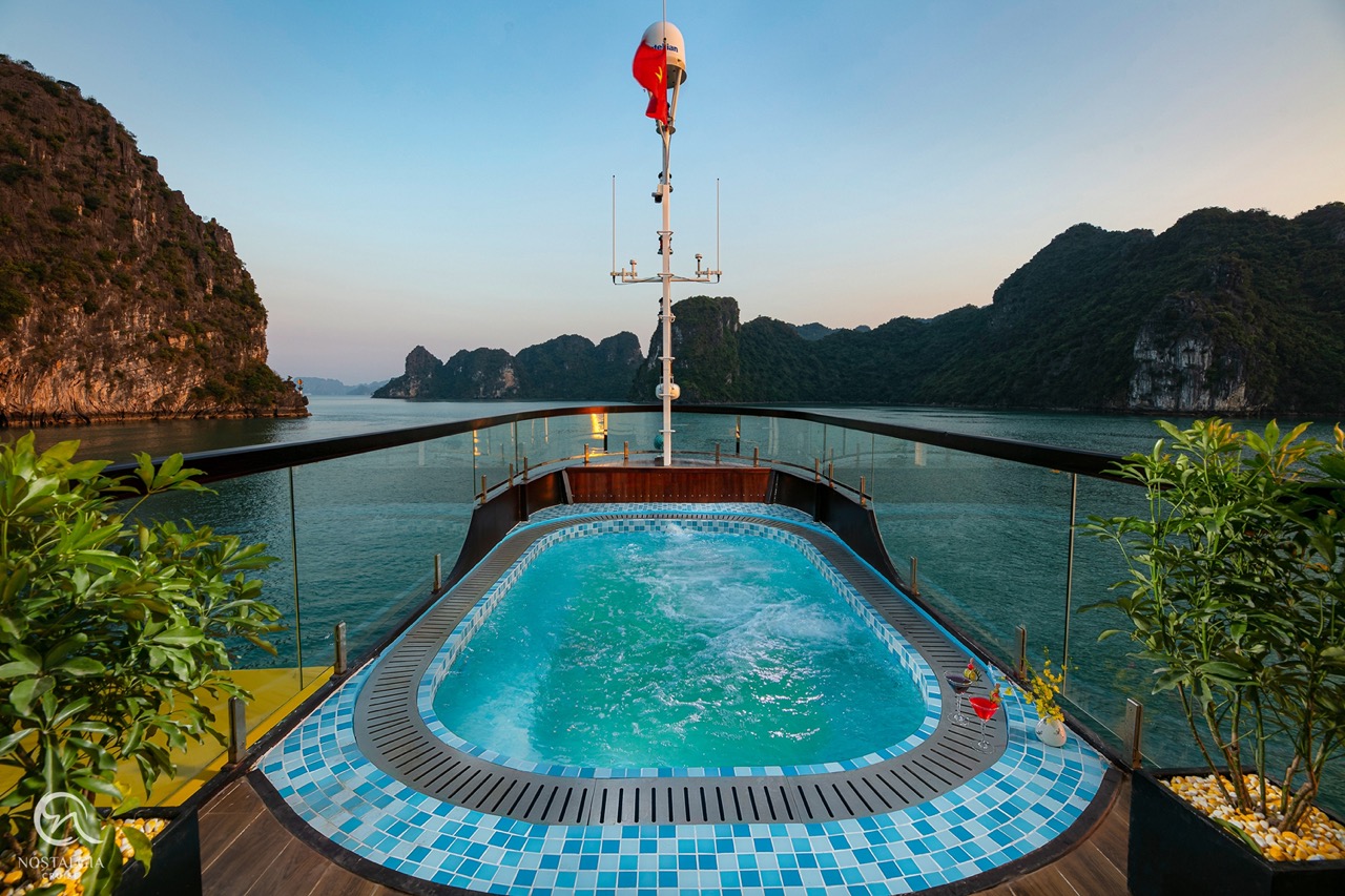 Stunning view from a cruise balcony in Halong Bay, showcasing limestone karsts and tranquil waters,.