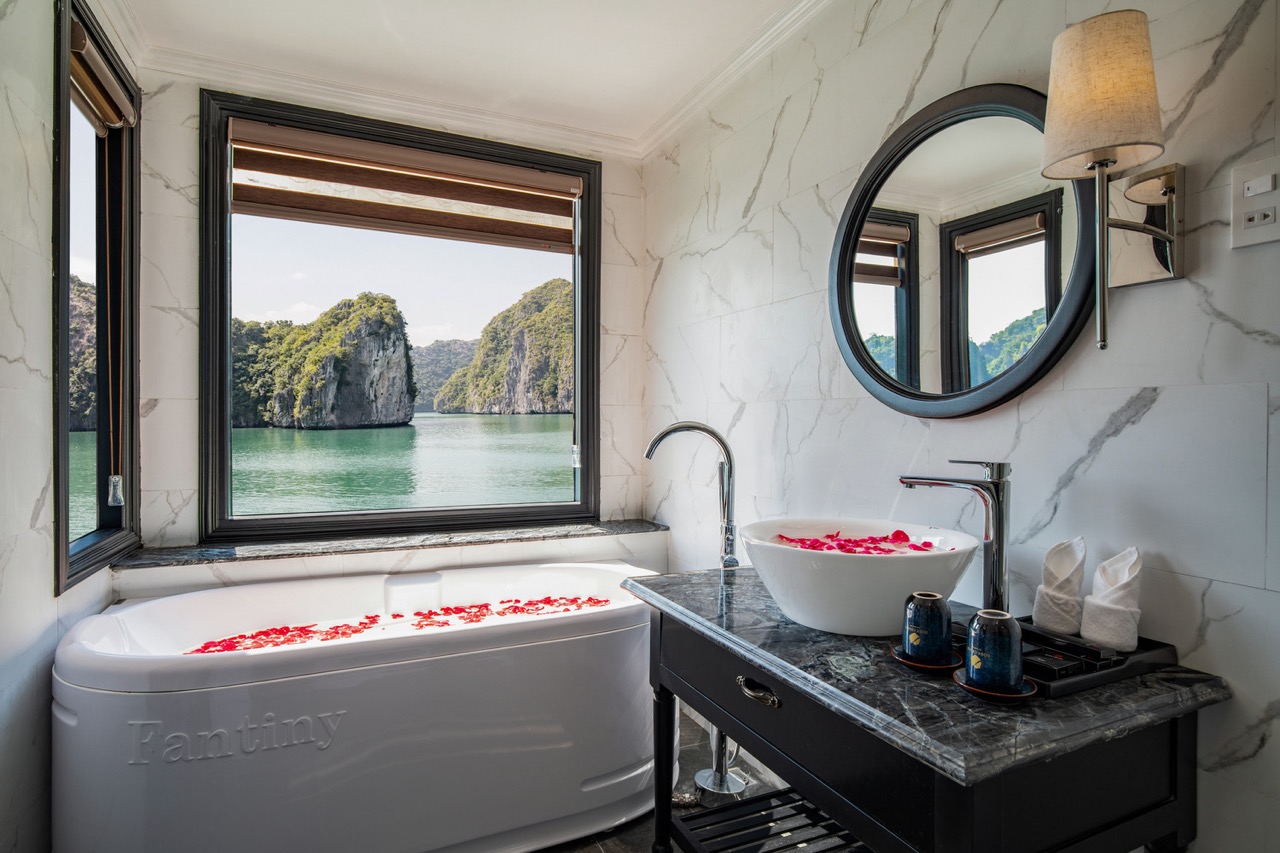 Stunning view of Halong Bay from a luxurious cruise balcony with relaxing bath and scenic limestone.