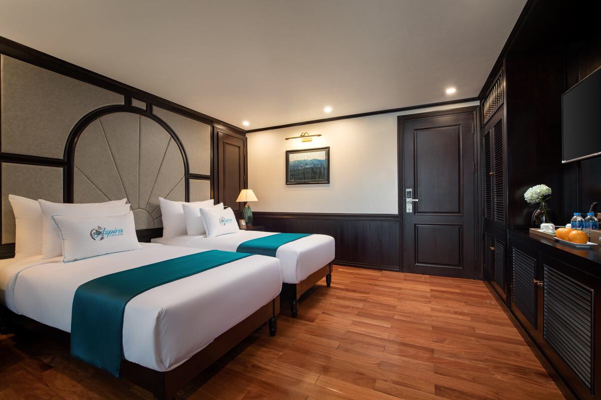 Comfortable hotel room with two beds, elegant dark wood decor, and modern amenities in Vietnam.