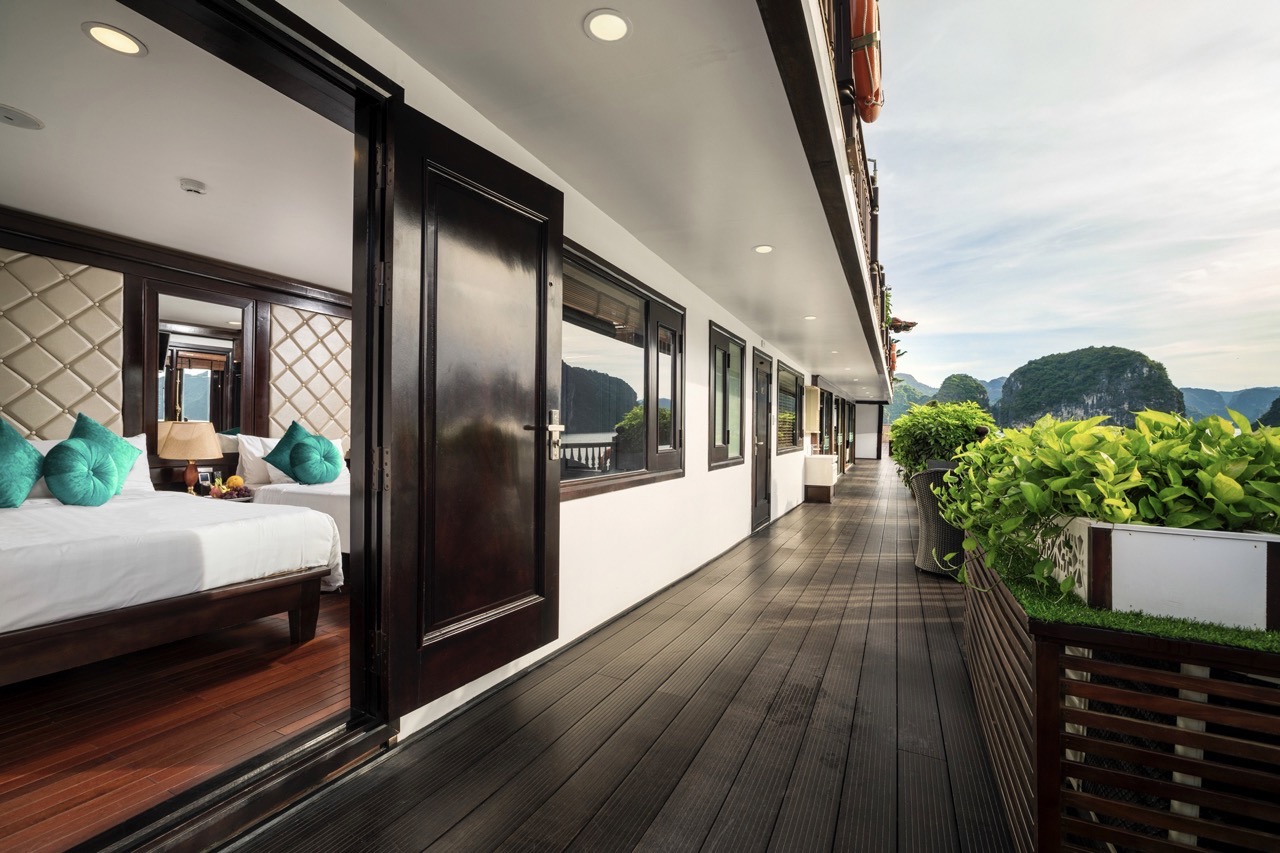 Scenic view of a luxury cruise balcony overlooking Halong Bay's stunning limestone karsts and emeral.