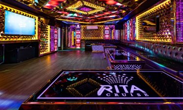 Luxurious cruise lounge with vibrant neon lights and modern decor on Halong Bay.