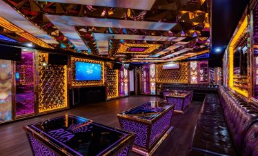 Luxurious cruise lounge with vibrant lighting and elegant decor in Halong Bay.