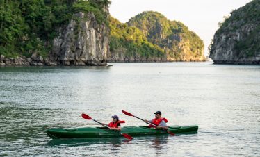 Kayaking in Halong Bay with scenic limestone islands and tranquil waters, perfect for adventure trav.