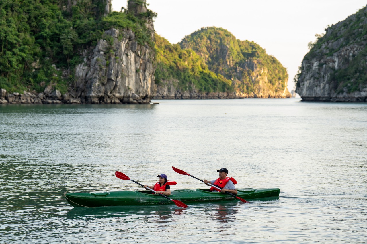 Kayaking in Halong Bay with scenic limestone islands and tranquil waters, perfect for adventure trav.