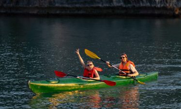 Kayaking adventure on Halong Bay with travelers enjoying scenic views and vibrant water activity.