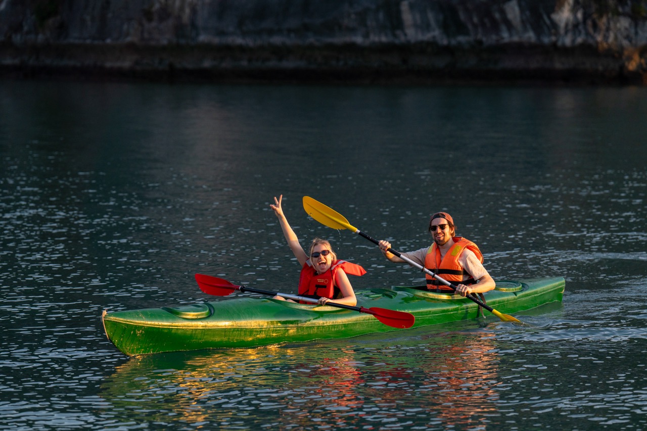 Kayaking adventure on Halong Bay with travelers enjoying scenic views and vibrant water activity.