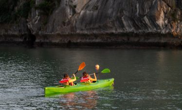 Kayaking adventure in Bai Tu Long Bay on a scenic cruise balcony.