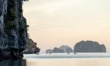 Scenic seascape of Bai Tu Long Bay with limestone islands and calm waters during sunset, perfect for.