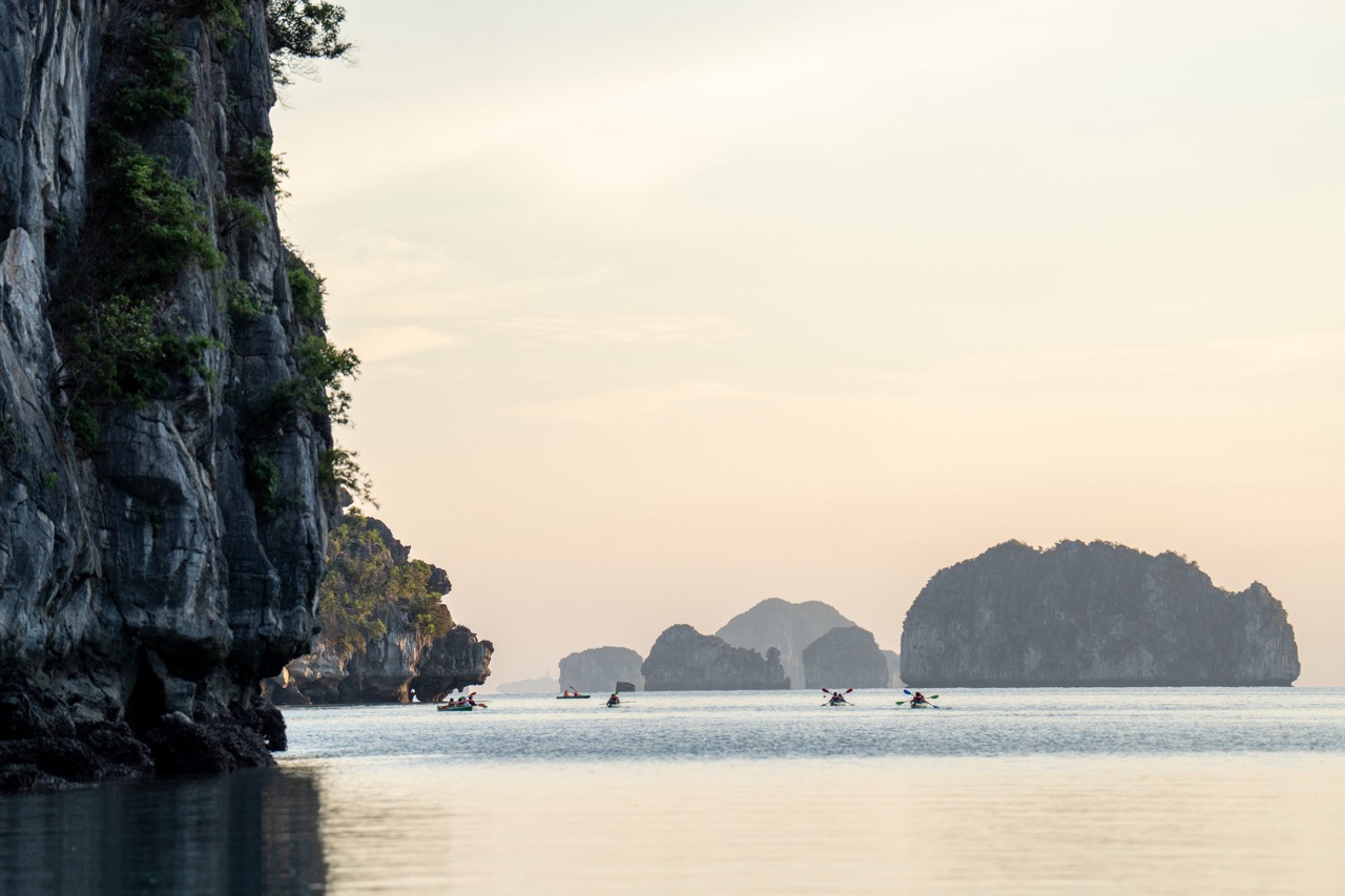 Scenic seascape of Bai Tu Long Bay with limestone islands and calm waters during sunset, perfect for.