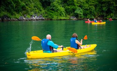 Kayaking in Halong Bay with lush green scenery and tranquil waters, perfect for an adventurous day o.