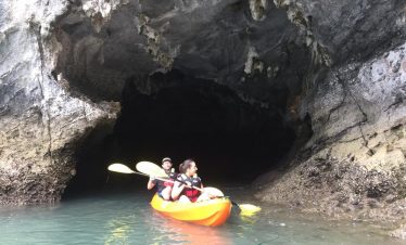 Kayaking adventure in Halong Bay with scenic limestone caves and tranquil waters.