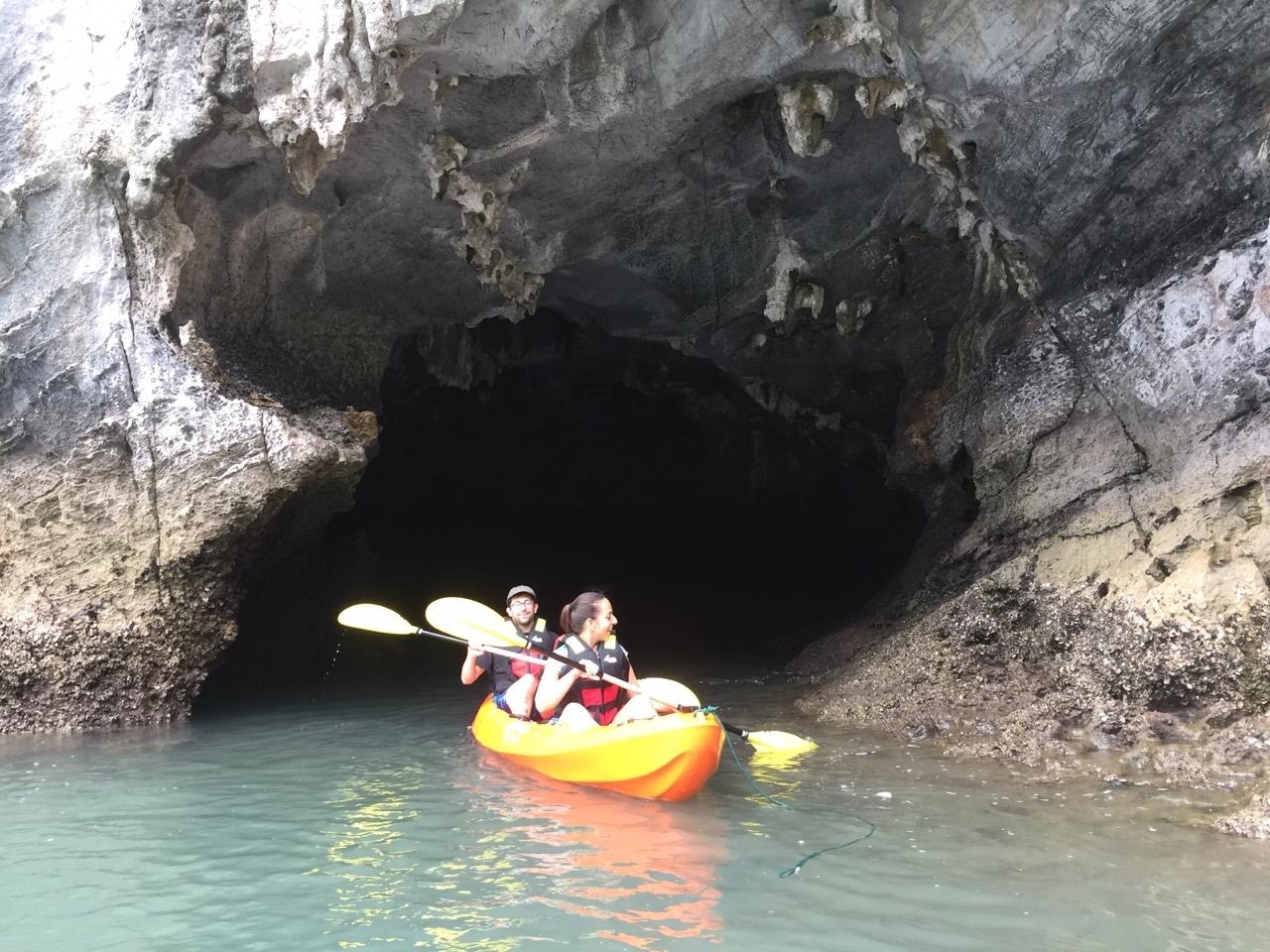 Kayaking adventure in Halong Bay with scenic limestone caves and tranquil waters.