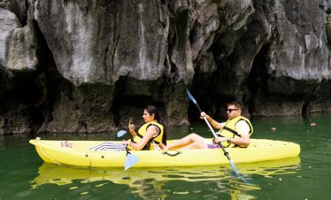Serene kayak adventure along limestone karsts in Vietnam's scenic landscape.