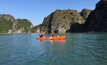Kayaking in Halong Bay with scenic limestone karsts and tranquil waters, perfect for adventure and r.