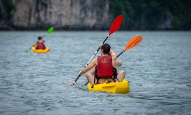 Kayaking in Halong Bay with vibrant scenery and tranquil waters, perfect for adventure and explorati.