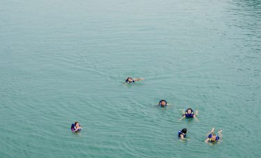 Beautiful scene of tourists kayaking on Halong Bay during daytime.