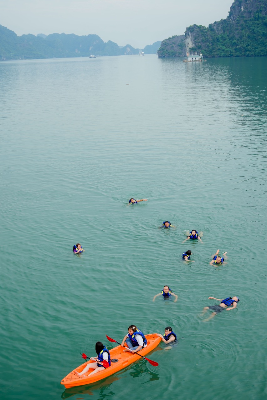 Beautiful scene of tourists kayaking on Halong Bay during daytime.