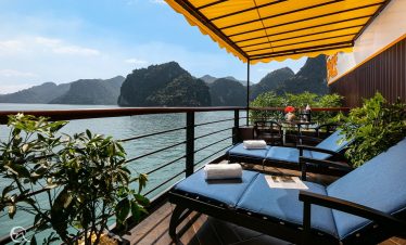 Stunning view from a luxury cruise balcony overlooking Halong Bay's emerald waters and limestone kar.