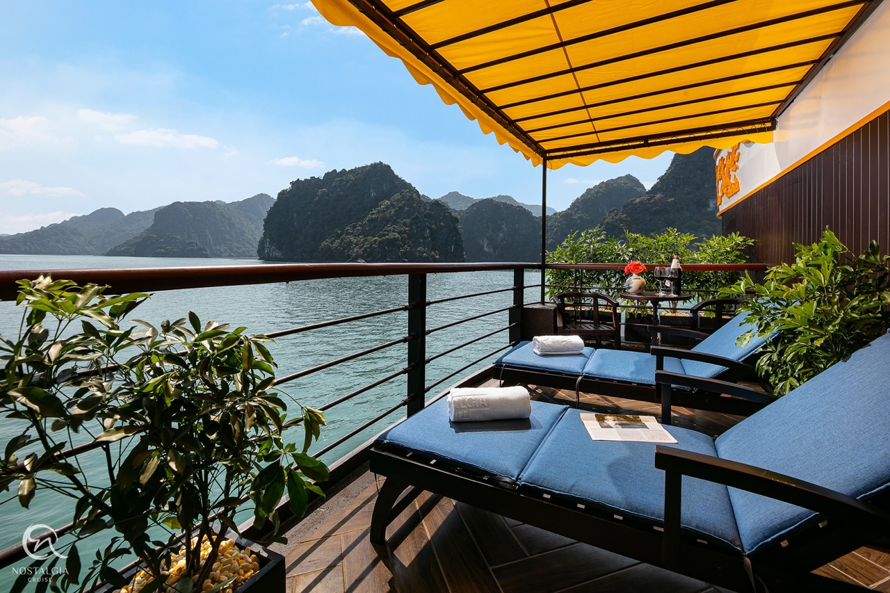 Stunning view from a luxury cruise balcony overlooking Halong Bay's emerald waters and limestone kar.