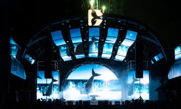 Whale-themed stage at Vietnam nightlife event with vibrant lights and performances.