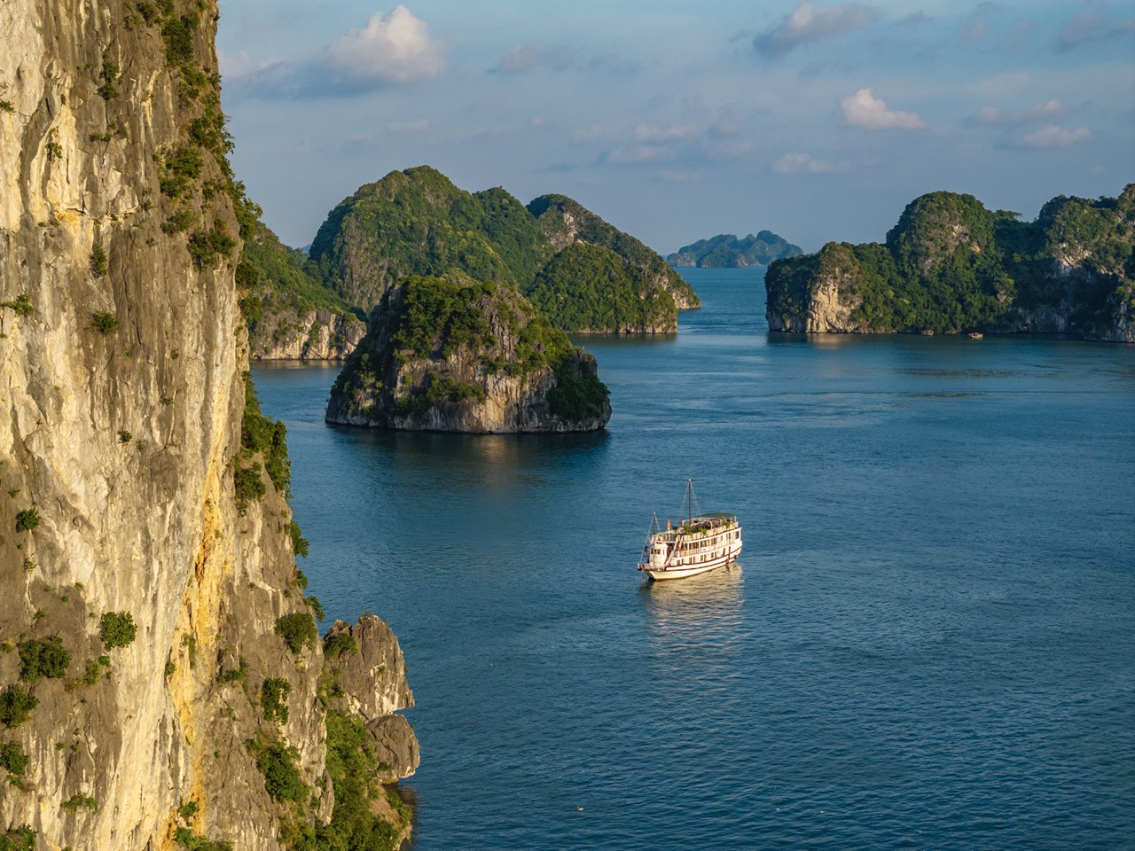 Stunning Halong Bay scenery with limestone karsts and calm waters, perfect for a relaxing cruise exp.