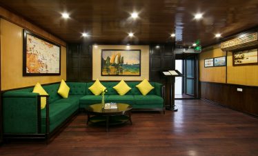 Relaxing cruise lounge with elegant decor and artwork, perfect for enjoying Halong Bay views.