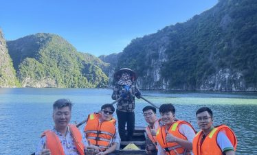 Kayaking in Halong Bay with stunning mountain backdrop, group enjoying scenic cruise and tranquil wa.