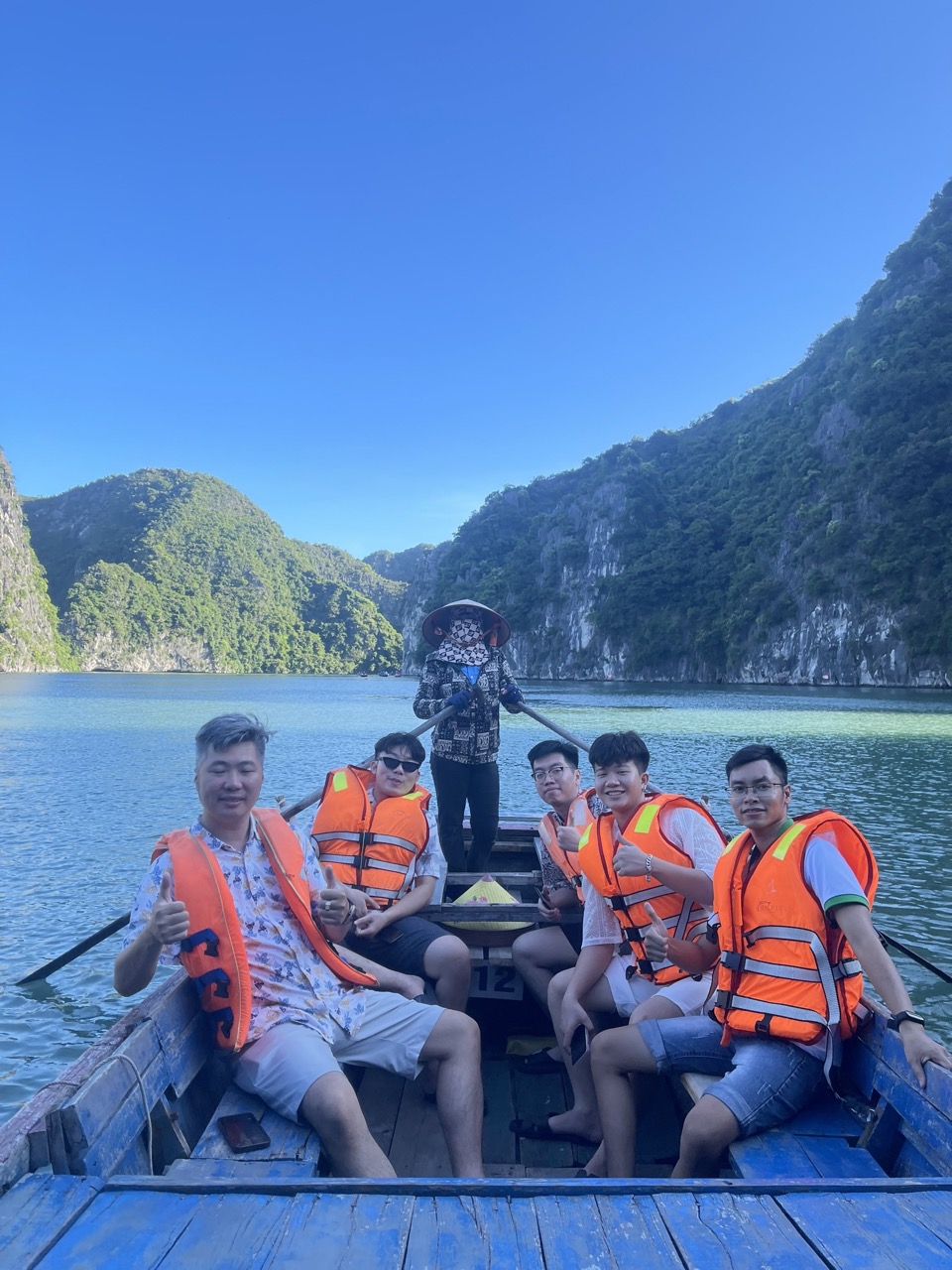Kayaking in Halong Bay with stunning mountain backdrop, group enjoying scenic cruise and tranquil wa.
