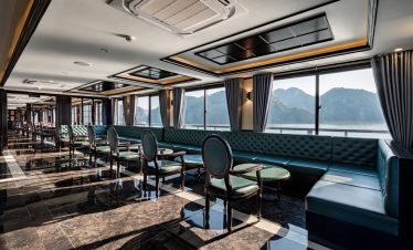 Elegant cruise lounge with large windows showcasing Halong Bay scenery, perfect for relaxing and enj.