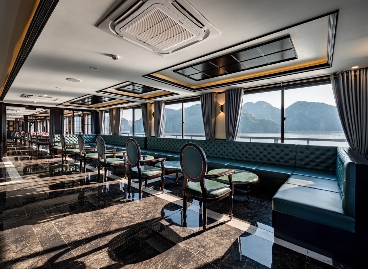 Elegant cruise lounge with large windows showcasing Halong Bay scenery, perfect for relaxing and enj.
