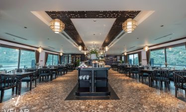 Luxurious cruise interior with panoramic windows, perfect for relaxing and enjoying Halong Bay views.