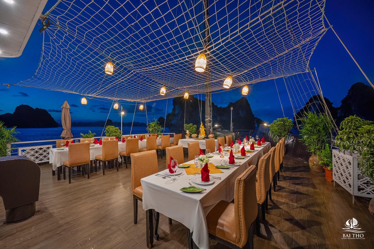 Elegant dining area on Bai Tu Long cruise with sunset views and cozy ambiance.