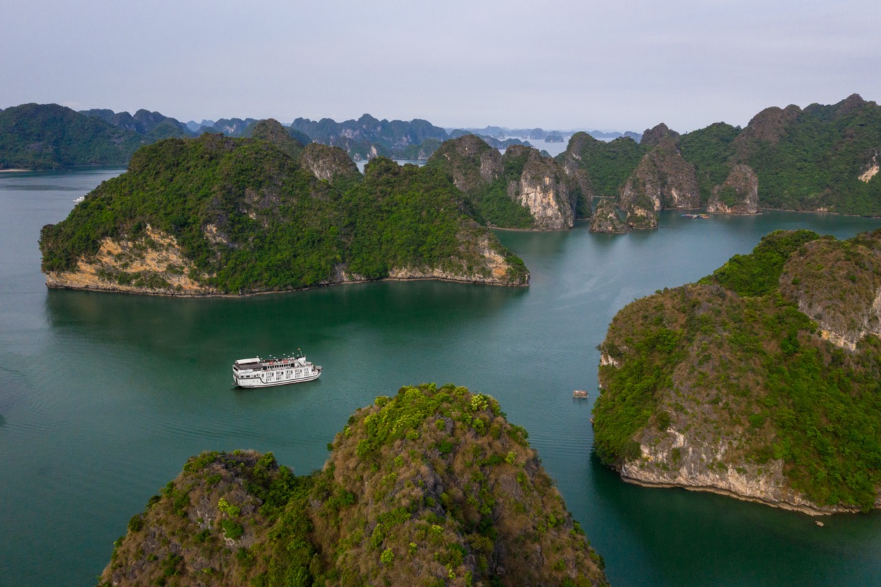 Stunning Halong Bay landscape with limestone karsts and a cruise ship, perfect for exploring scenic.