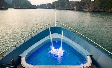 A luxurious cruise balcony in Halong Bay offering stunning views of limestone karsts and tranquil wa.