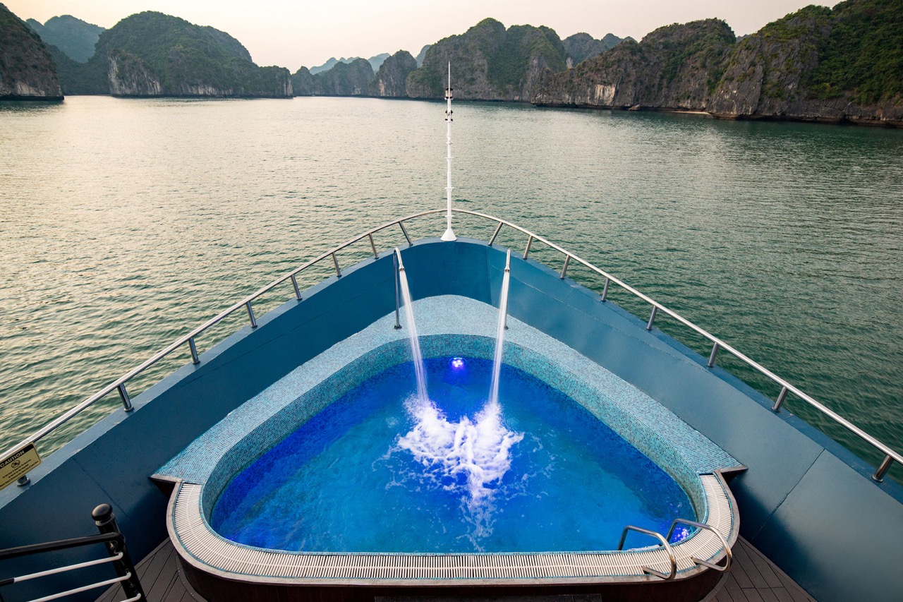 A luxurious cruise balcony in Halong Bay offering stunning views of limestone karsts and tranquil wa.