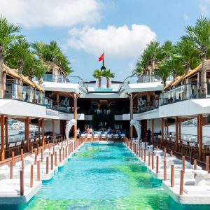 Luxurious waterfront resort with pools, palm trees, and ocean views in Vietnam.