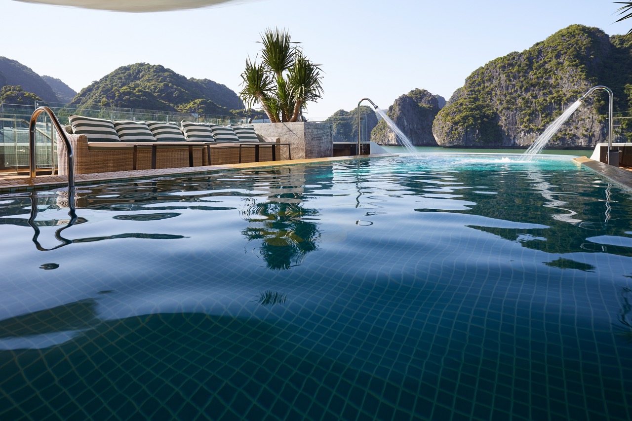 Stunning view of Halong Bay from a cruise balcony with lush islands in the background.